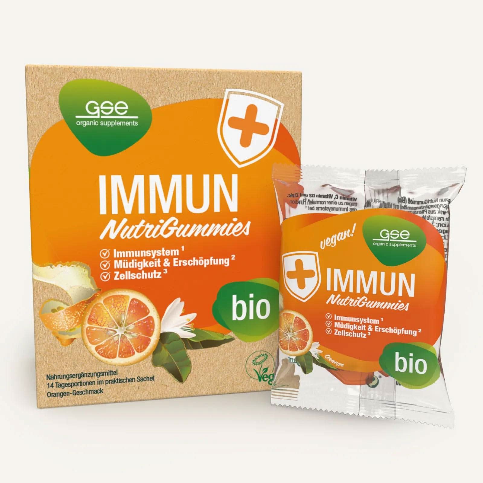 Eine Schachtel und ein Beutel Immun NutriGummies (Bio) von gse.organic.supplements mit Orangenscheibe und Gummibärchen-Motiv. Die Verpackung unterstreicht die Immununterstützung durch Vitamin C und die Reduzierung von Müdigkeit für ein starkes Immunsystem.