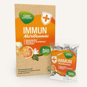 Eine Schachtel und ein Beutel Immun NutriGummies (Bio) von gse.organic.supplements mit Orangen- und Blattbildern sowie den Etiketten „Bio“ und „Vegan“ betonen die Unterstützung des Immunsystems mit Vitamin C und Zink als Hauptbestandteil.