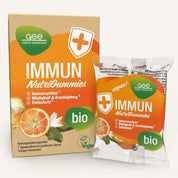 Eine Schachtel und ein Beutel Immun NutriGummies (Bio) von gse.organic.supplements, reich an Vitamin C, mit der Aufschrift „Bio“ und „vegan“, verfügen über ein Orange-Zitrus-Design zur Unterstützung des Immunsystems und zur Verringerung von Müdigkeit.