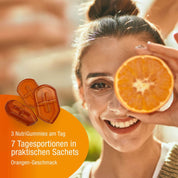 Eine lächelnde Frau hält sich eine halbe Orange vors Auge. Im Vordergrund sind die Immun NutriGummies (Bio) von gse.organic.supplements mit Vitamin C abgebildet. Sie enthalten 7 Tagesportionen in praktischen Beuteln und unterstützen mit leckerem Orangengeschmack Ihr Immunsystem.