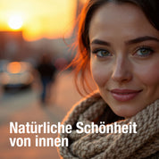 Eine Frau mit grünen Augen und einem Strickschal lächelt sanft in den Sonnenuntergang. Unscharfe Menschen und warmes Sonnenlicht hinter ihr. Text: Natürliche Schönheit von innen - mit dem Beauty Boost Paket von gse organic supplements für Haut, Haare & Nägel.