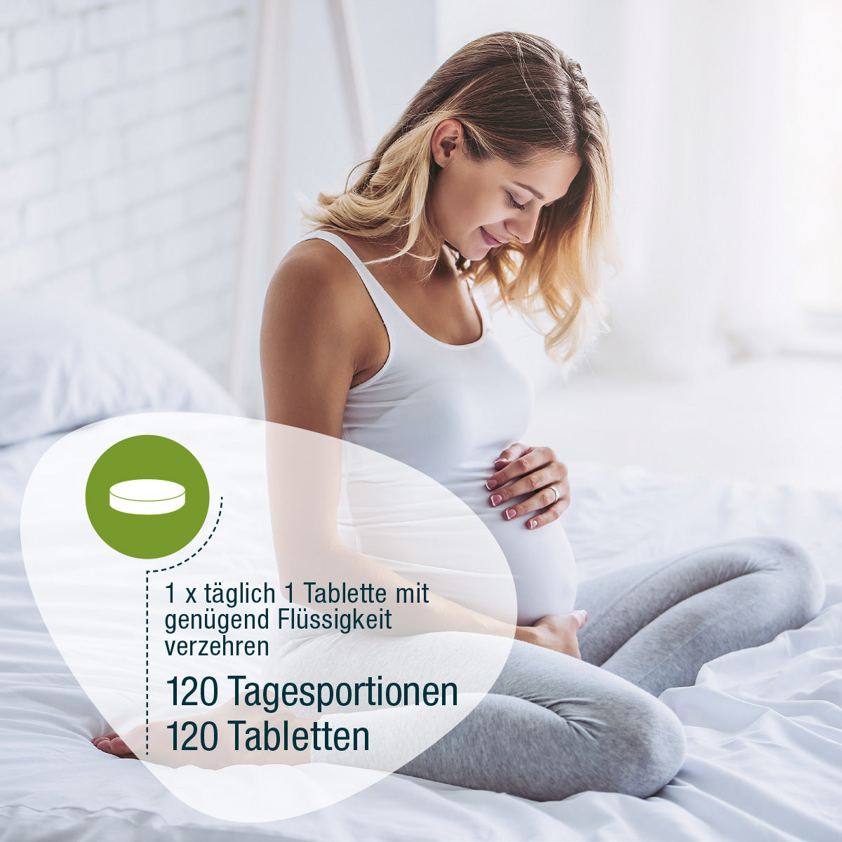 Eine schwangere Frau in einem weißen Tanktop und grauen Leggings sitzt im Schneidersitz auf einem Bett, lächelt und hält sanft ihren Bauch. Überlagerter deutscher Text teilt gse.organic.supplements Folsäure Compact (Bio) Dosierung für Schwangerschaft und Stillzeit.