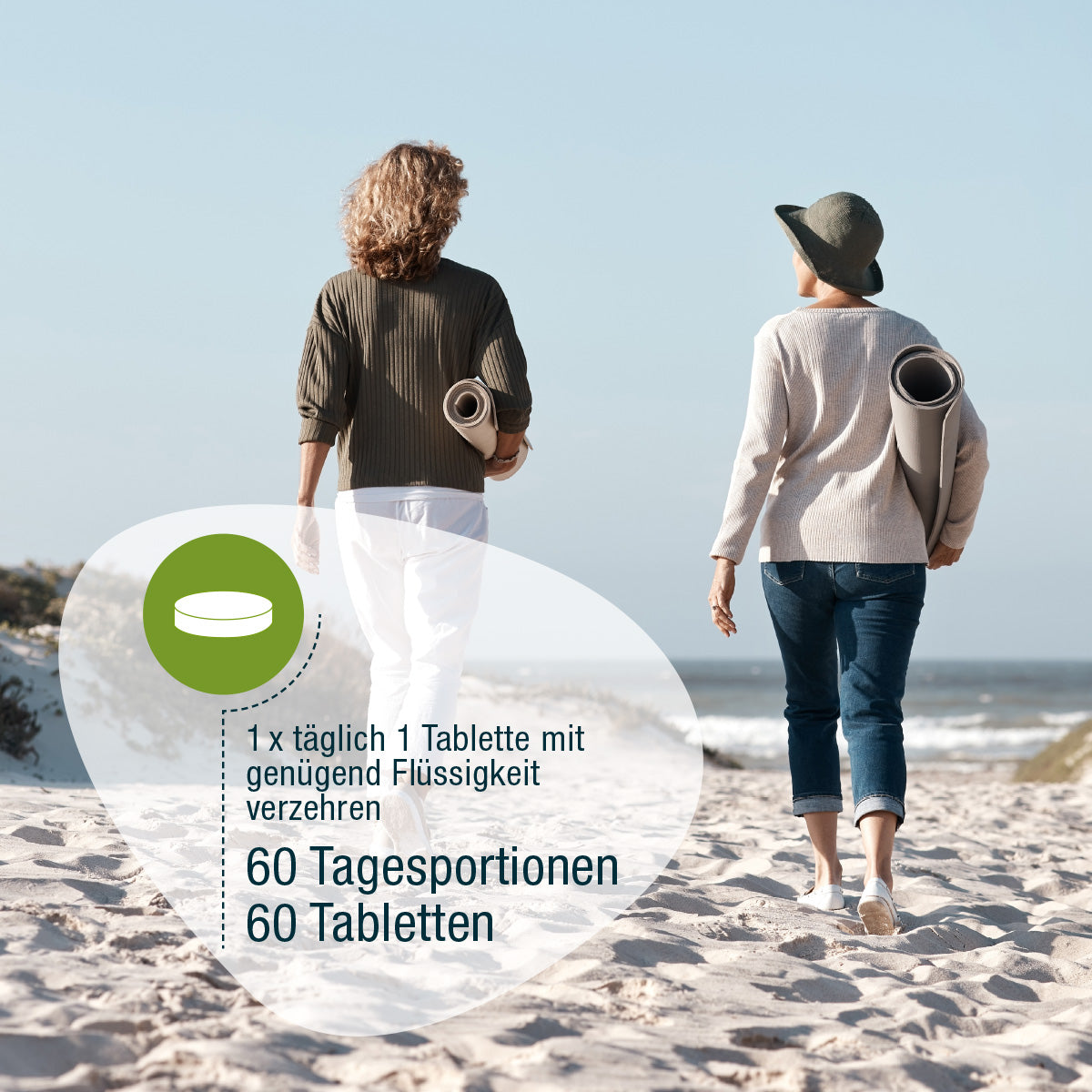 Zwei Frauen spazieren entspannt mit Yoga-Matten am Strand. Overlay-Text auf Deutsch empfohlen: Täglich eine Tablette Frauen Vital Complex (Bio) von gse.organic.supplements mit Wasser einnehmen - 60 Tage pflanzliche Bio-Vitamine.