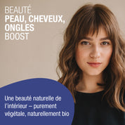 Eine Frau mit hellbraunem Haar und Pony steht vor einem neutralen Hintergrund. Der französische Text wirbt für gse.organic.supplements Beauty Haut, Haare, Nägel Boost (Bio) FR für natürliche Schönheit von Haut, Haaren und Nägeln mit pflanzlichen Inhaltsstoffen wie Selen und B-Vitaminen.