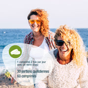 Zwei lächelnde Frauen mit lockigem Haar und Sonnenbrille genießen einen sonnigen Tag am Meer. Der eingeblendete französische Text informiert über die Dosierung des OPC Zellschutz Complex (Bio) FR Ergänzungsmittels von gse.organic.supplements, das das tägliche Wohlbefinden unterstützt.
