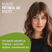 Eine junge Frau mit hellbraunem Haar und Pony posiert vor einem beigen Hintergrund. Der französische Text bewirbt Beauty Retinol-AE Boost (Bio) FR von gse.organic.supplements, ein pflanzliches Bio-Schönheitsprodukt mit Retinol und Biotin.
