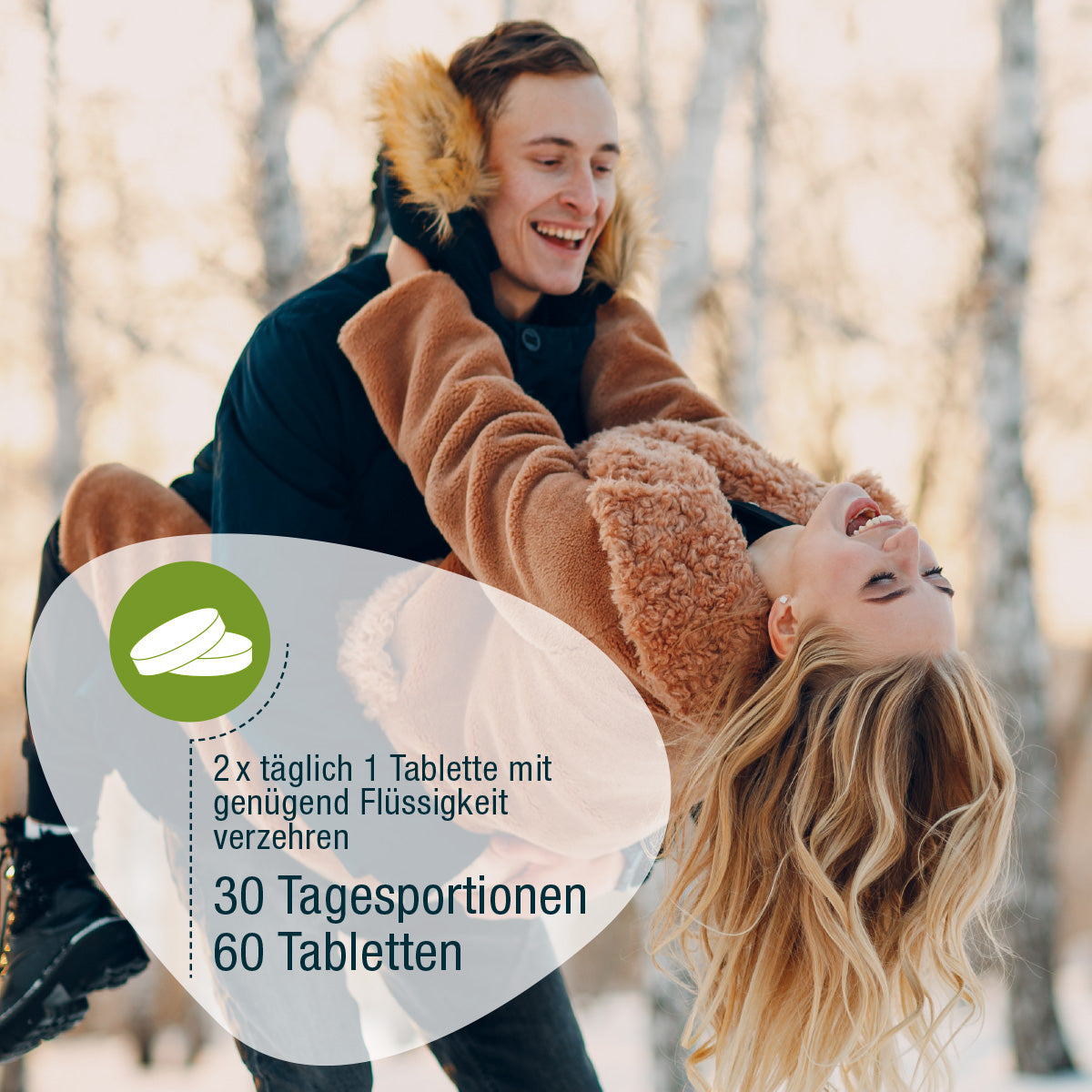 Ein Mann hebt eine lachende Frau in einem verschneiten Birkenwald hoch. Deutscher Text fördert gse.organic.supplements Zink & Vitamin C (Bio): 2x täglich 1 Tablette mit viel Flüssigkeit, stärkt das Immunsystem, 30 Tage, 60 Tabletten.