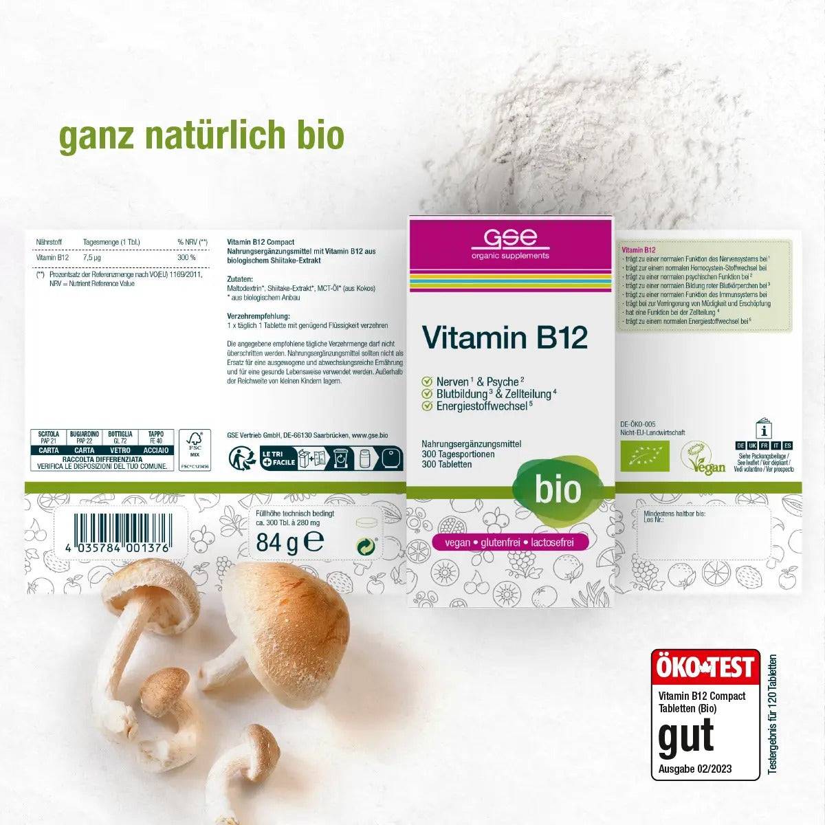 Eine Schachtel Vitamin B12 Compact (Bio) Tabletten von gse.organic.supplements mit deutschen Produktdetails, Bio- und Vegan-Etiketten steht neben Champignons und Pulver. In der unteren rechten Ecke ist ein ÖKO-TEST-Siegel zu sehen.