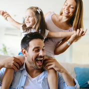 Eine fröhliche dreiköpfige Familie spielt drinnen und strahlt dieselbe lebendige Energie aus wie CitroPlus® - Grapefruitkern-Extrakt 600 von gse.organic.supplements.