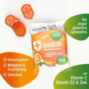 Eine Packung Immun NutriGummies (Bio) von gse.organic.supplements mit zwei orangefarbenen, schildförmigen Gummibärchen daneben. Bio, vegan, glutenfrei, laktosefrei; enthält Vitamin C, D3 und Zink zur Unterstützung der Immunität und zum Schutz der Zellen.