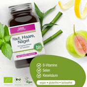 Eine Flasche gse.organic.supplements Haut, Haare, Nägel Complex (Bio) steht auf einem weißen Untergrund mit grünen Blättern, Bambus, Früchten und Tabletten. Auf dem Etikett sind vegane B-Vitamine aus Guaven- und Basilikumextrakt zu sehen.